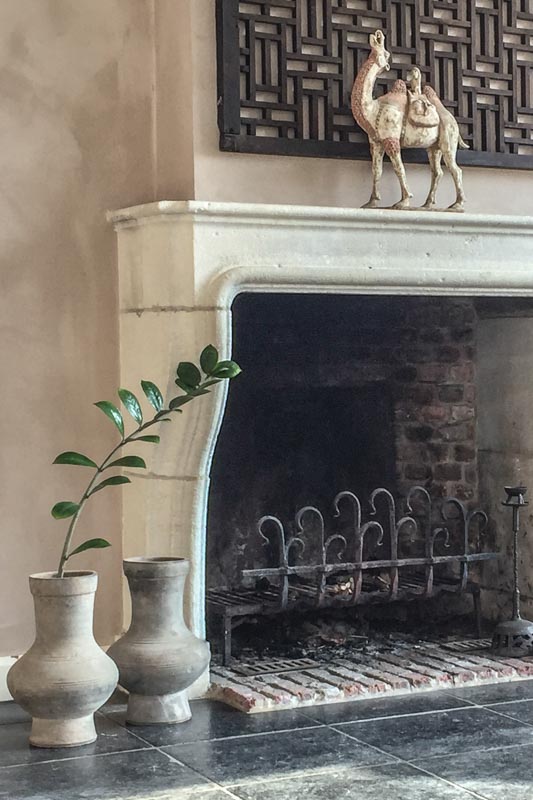 A wabi sabi interior with repro Han pots and an ancient camel statue from the Han dynasty